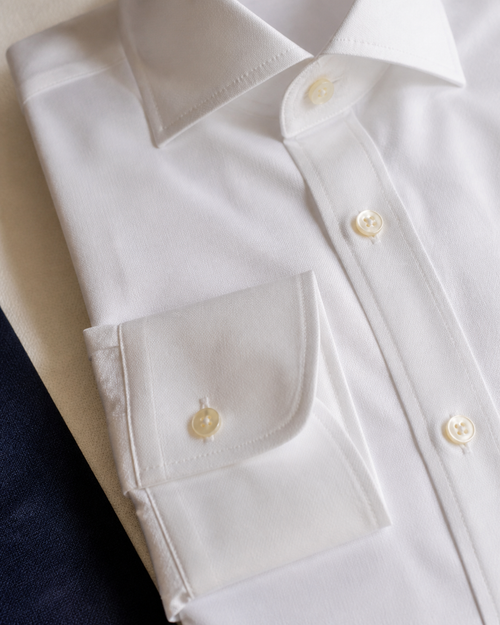 Detalhe de colarinho, punho e botões da camisa branca Oxford